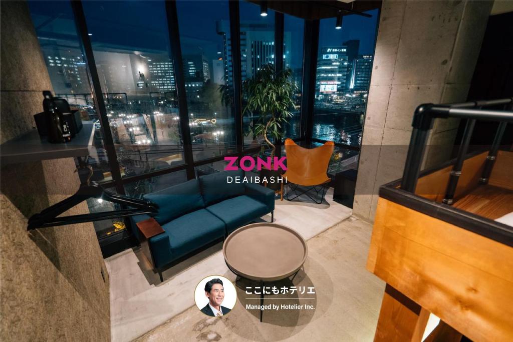 a view of a living room with a blue couch at ZONK HOTEL Nakasu-Deaibashi in Fukuoka