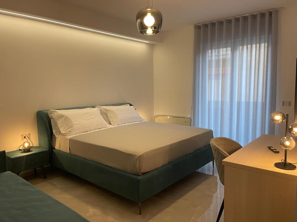 a bedroom with a bed and a desk and a window at Xenia Room in Gela