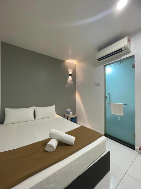 a bedroom with a bed with a towel on it at Collection O Malacca Formerly Lavender Inn in Malacca
