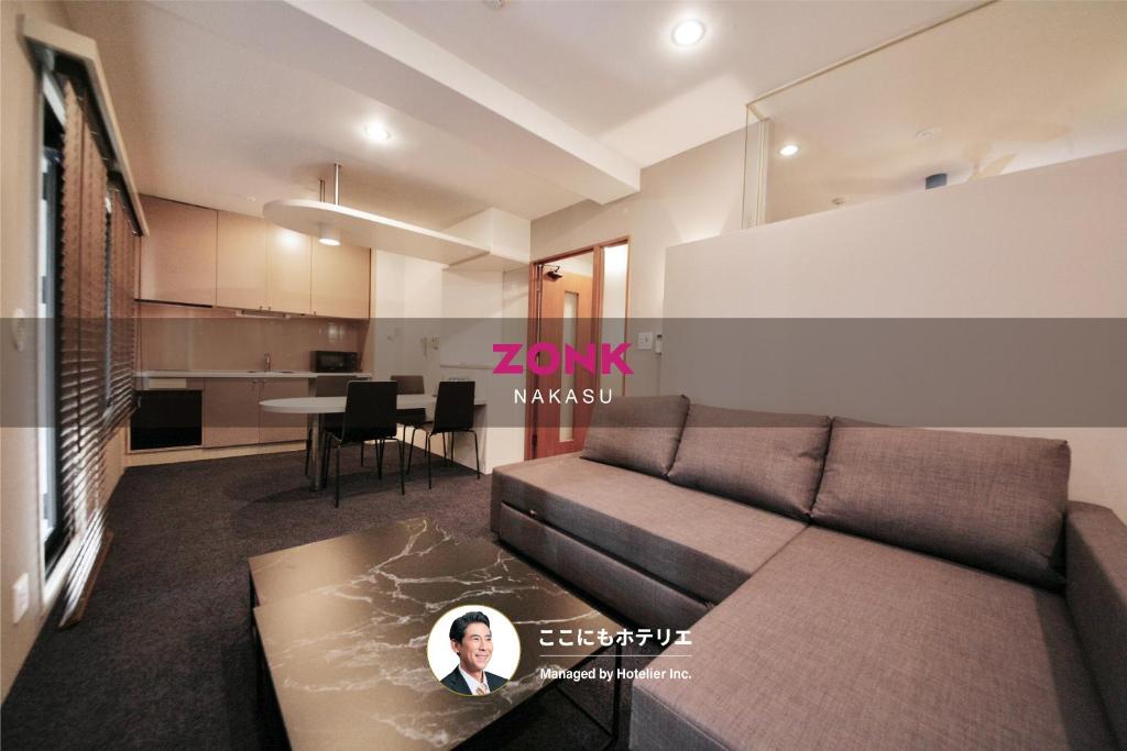 a living room with a couch and a table at ZONK HOTEL Nakasu in Fukuoka