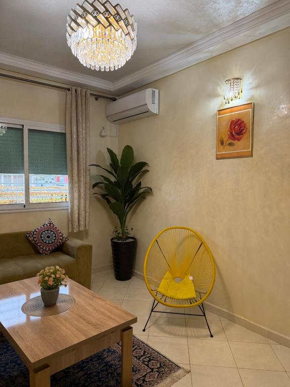 a living room with a table and a yellow chair at Home louah in Fez