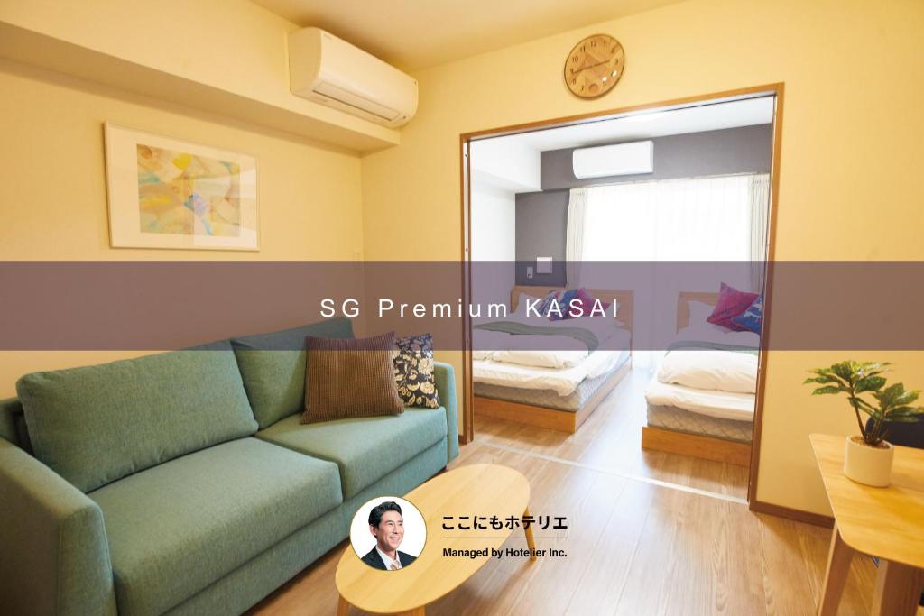 a living room with a green couch and a mirror at SG Premium KASAI in Tokyo
