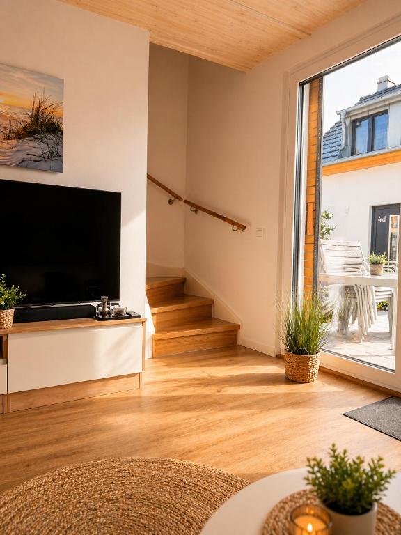 a living room with a large television and a staircase at Inselheimat Dranske in Dranske