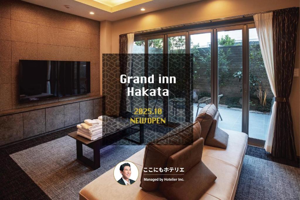 a living room with a couch and a tv at Grand Inn Hakata in Fukuoka