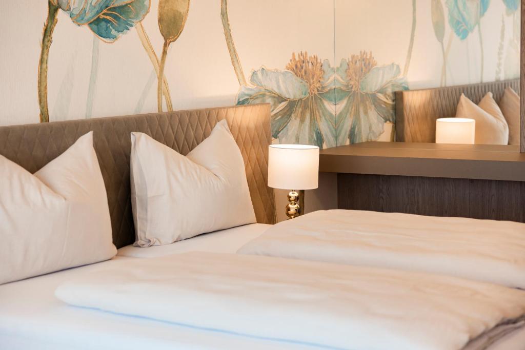 a bed with white pillows and a lamp next to it at CIRCLE Boutique Hotel Melk in Melk