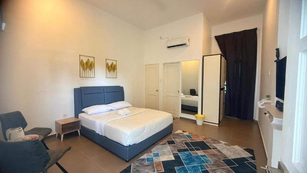 a bedroom with a bed and a chair in it at Hotel O HNR INN in Kuala Terengganu