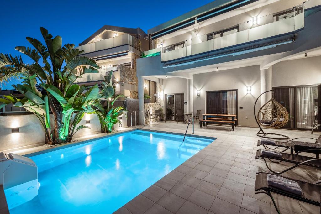 a swimming pool in the backyard of a house at Old Cinema Suites - Stylishly Decorated Retreat with Pool or Jacuzzi by the Sea in the Heart of Laganas Βy Villa Mana Gers in Laganas