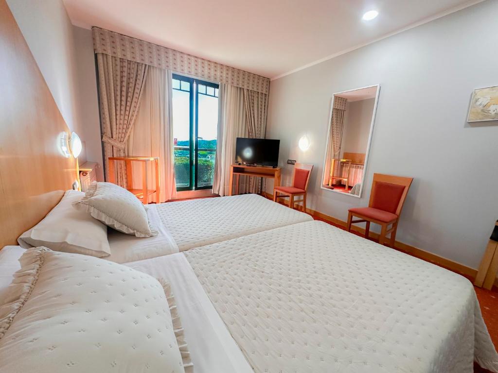 a hotel room with a large bed and a television at Hotel Mirador de Gornazo in Gormazo