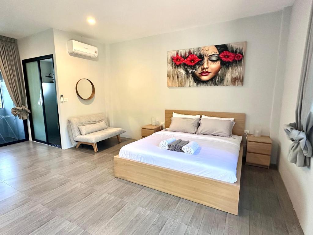 a bedroom with a bed and a painting of a woman at Acqua Rooms & Living in Koh Samui