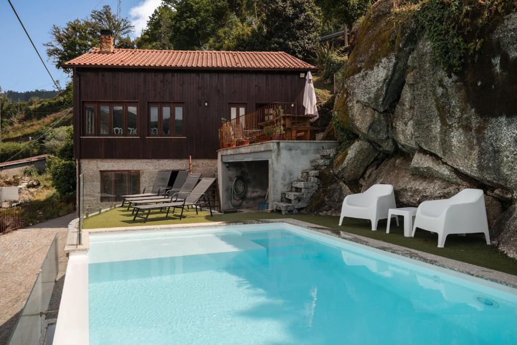 a villa with a swimming pool and a house at Casa Pinhão De Sousa in Vieira do Minho