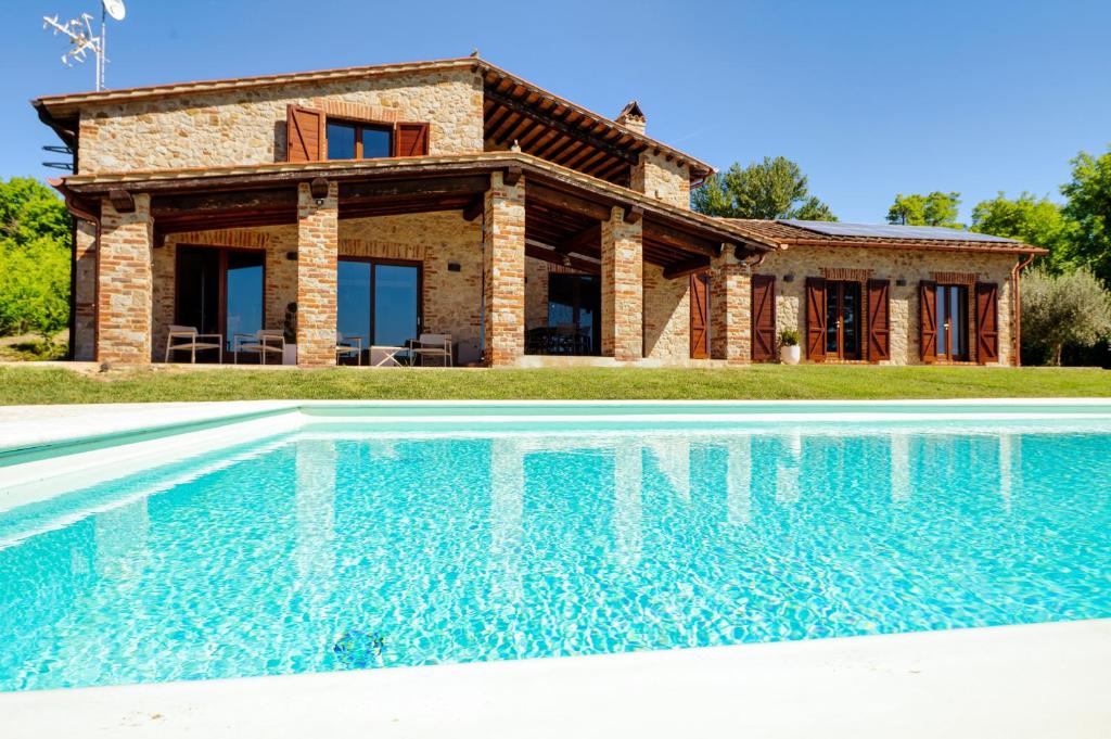 a house with a swimming pool in front of a house at San Venanzo – Casale De' Conti in San Venanzo