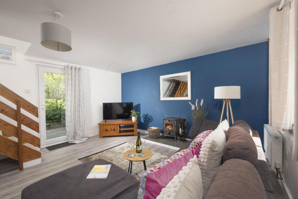 a living room with a couch and a blue wall at Aval Dor Barn, Hot Tub, Pet Friendly in Ludgvan