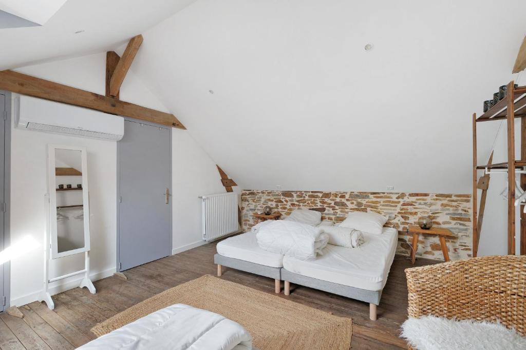 a living room with a white couch and a brick wall at Bulle de Douceur avec Spa in Vallons-de-l'Erdre