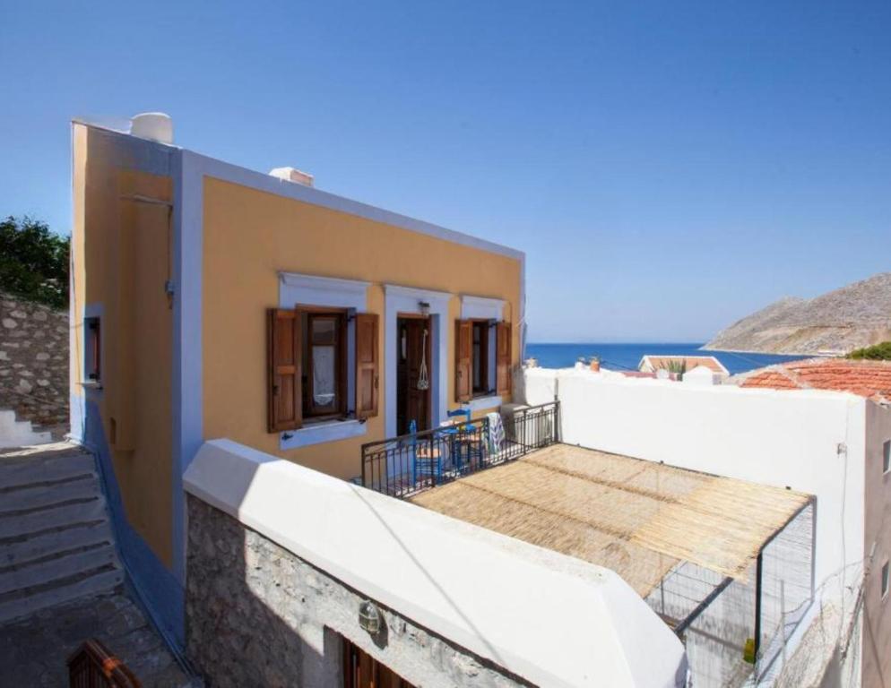 a house with a balcony with a view of the ocean at Avra in Symi