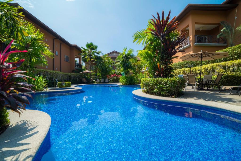 a swimming pool in front of a house at Veranda 3G 2 bdr Garden View in Los Suenos in Jacó