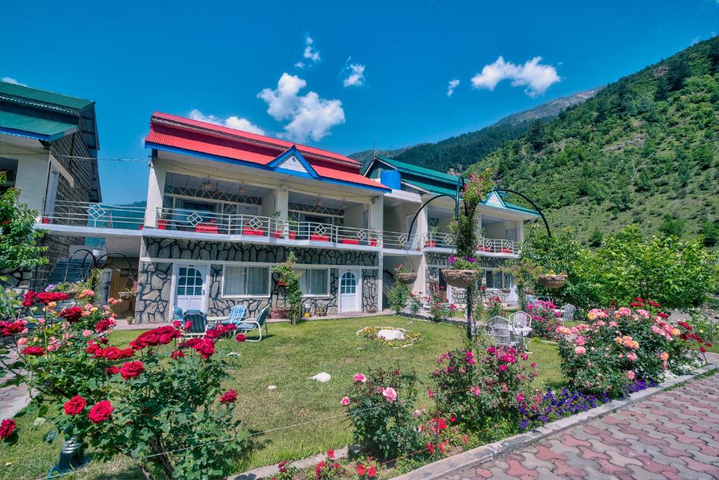 a house with flowers in front of it at Parhena Cottages Bella Naran in Naran