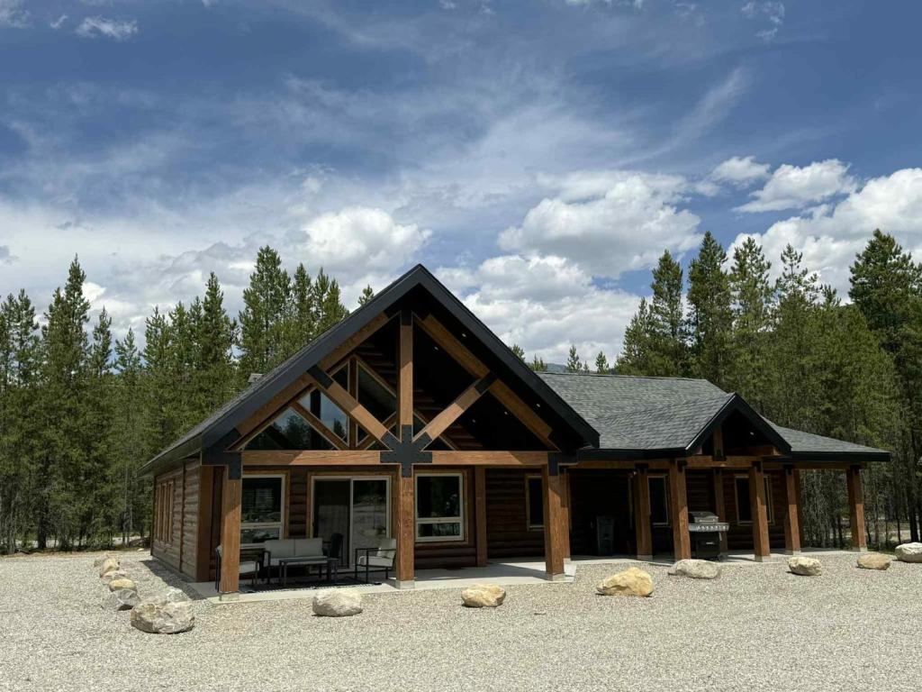 a large log cabin with a black roof at Polar Den Cabin in Valemount