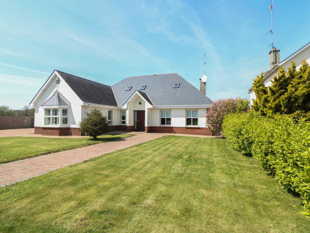 a white house with a grass yard at Sunnyside in Riverchapel