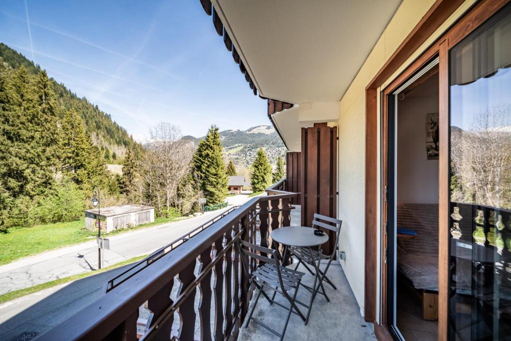 a balcony with a table and a view of a road at Appartement vue montagne - Chatel in Châtel