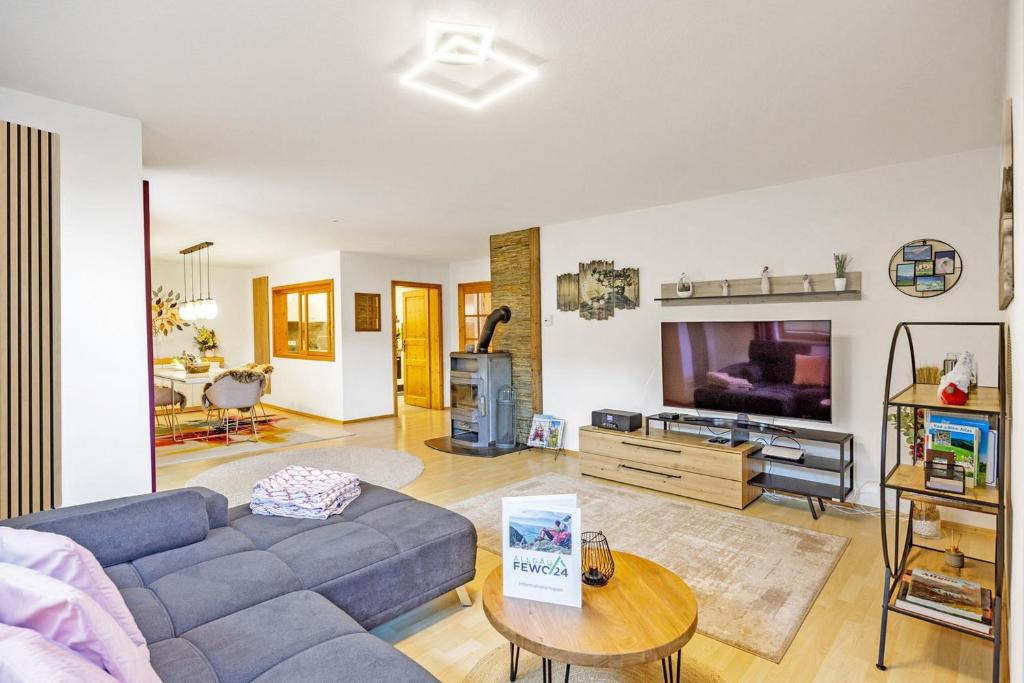 a living room with a couch and a tv at Freigeist in Nesselwang
