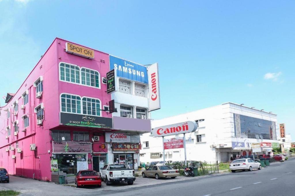a pink building on the side of a street at Hotel O D'noor in Kota Bharu