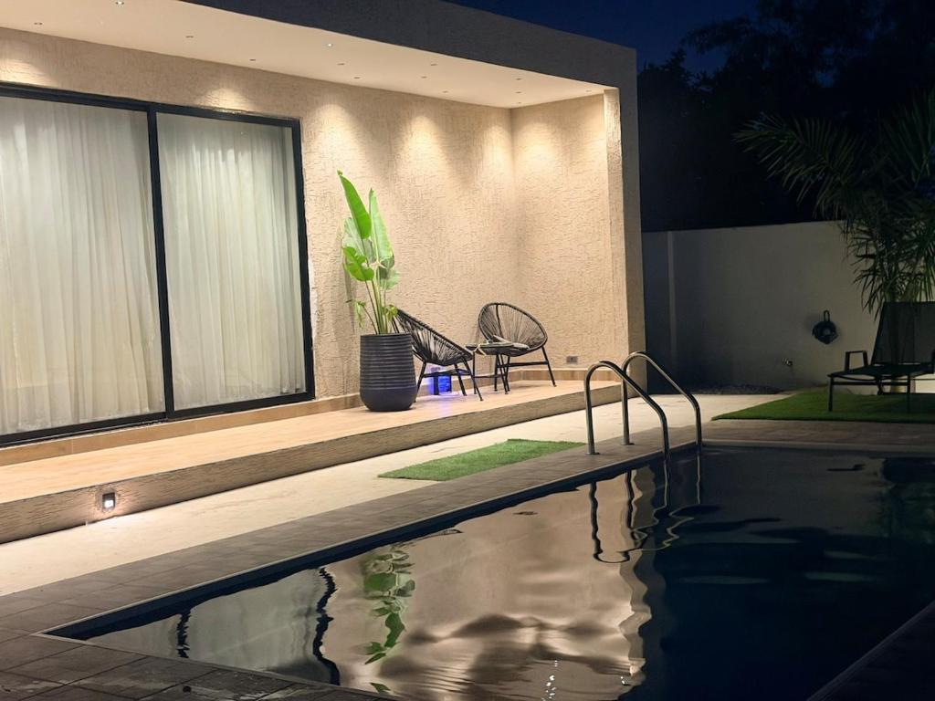 a house with a swimming pool in front of it at Villa Pravo in Kasoa
