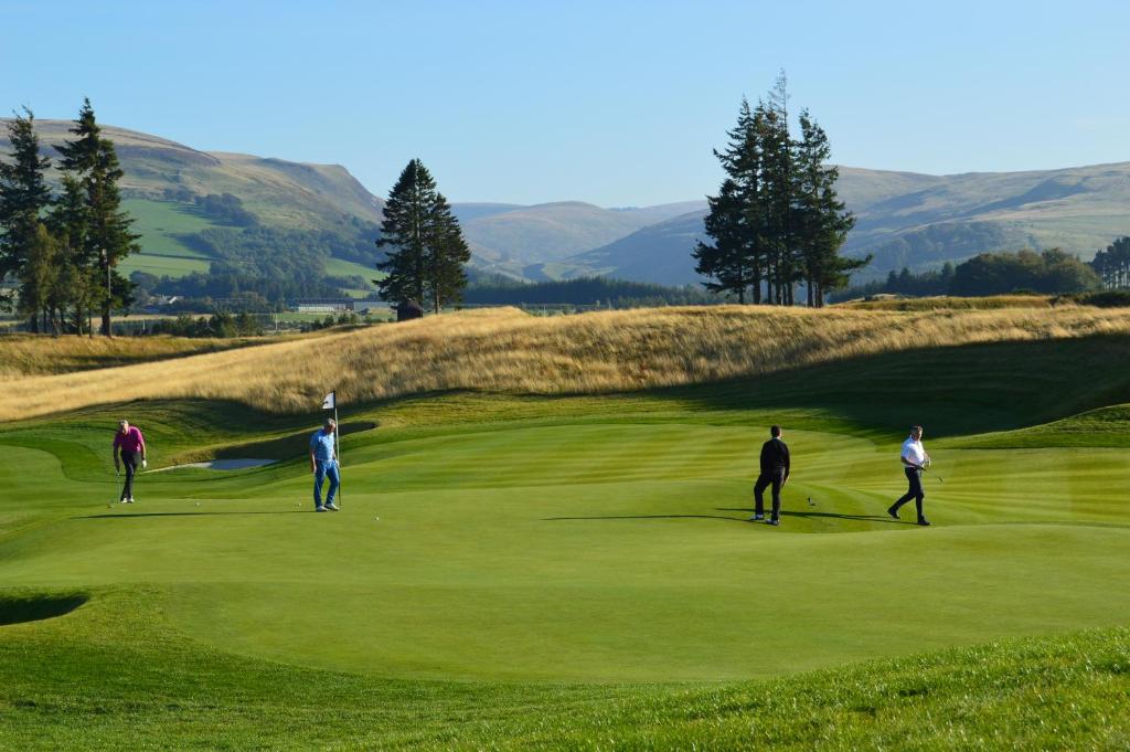 a group of people playing golf on a golf course at The Pines - Stunning 3 Bedroomed Apartment, Gleneagles in Auchterarder