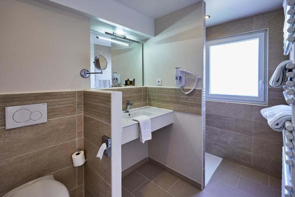 a bathroom with a sink and a shower at Les Villas d'Arromanches, Teritoria in Arromanches-les-Bains