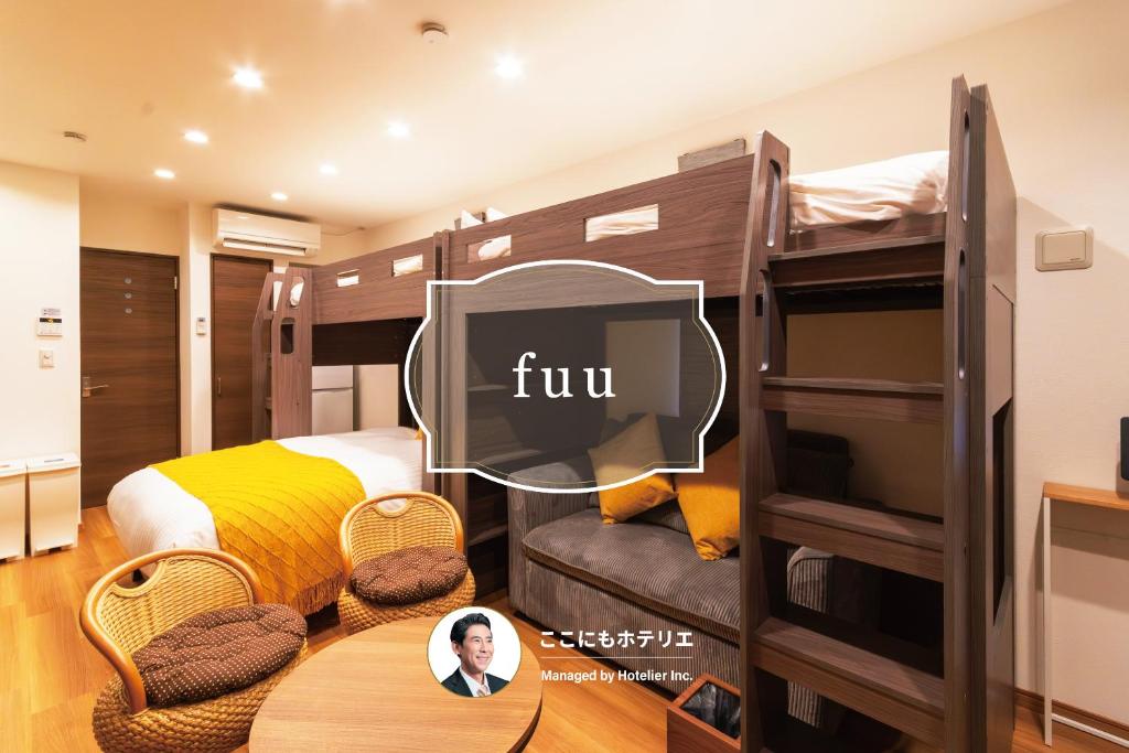 a room with bunk beds with a table and a tv at fuu in Fukuoka