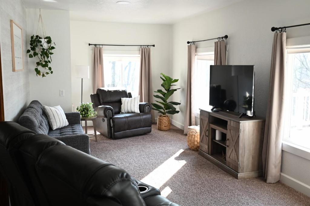a living room with a couch and a flat screen tv at Pondside Abode in Dundee