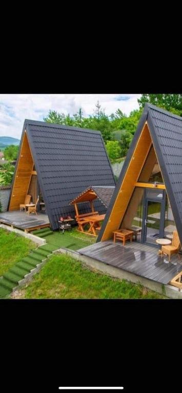 a large house with a roof with a picnic table at Casute A frame in Jiblea Veche