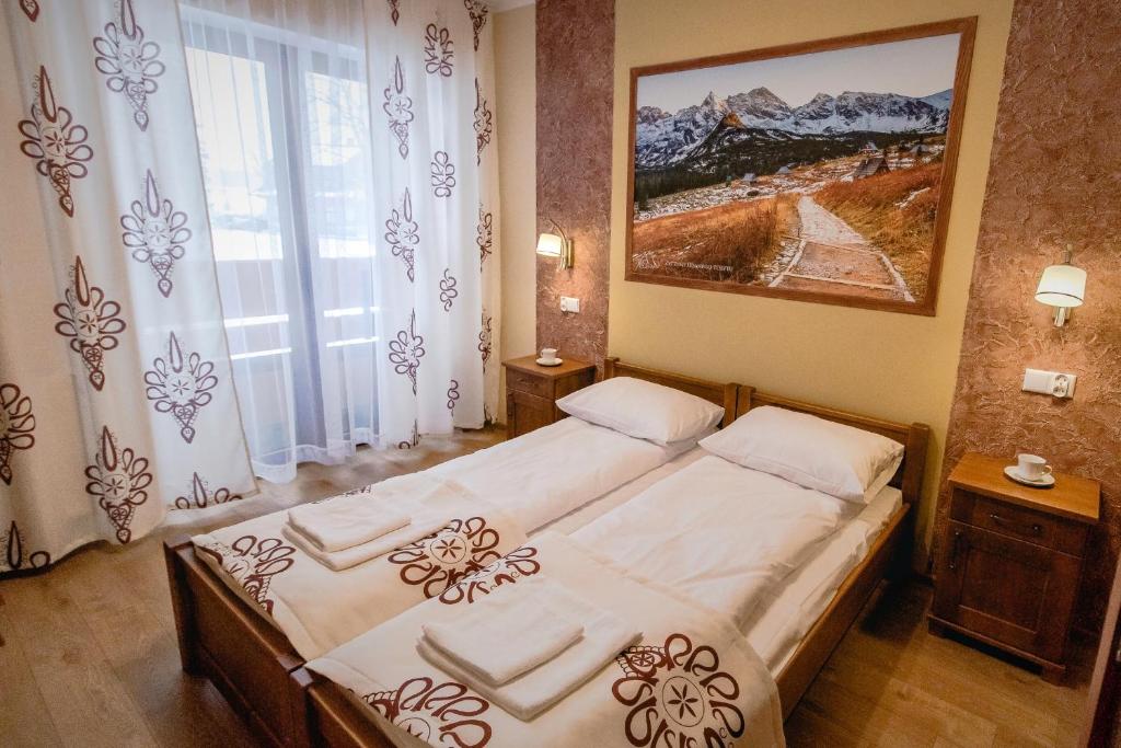 een slaapkamer met 2 bedden en een groot raam bij Dom Wczasowy Na Szczycie in Zakopane