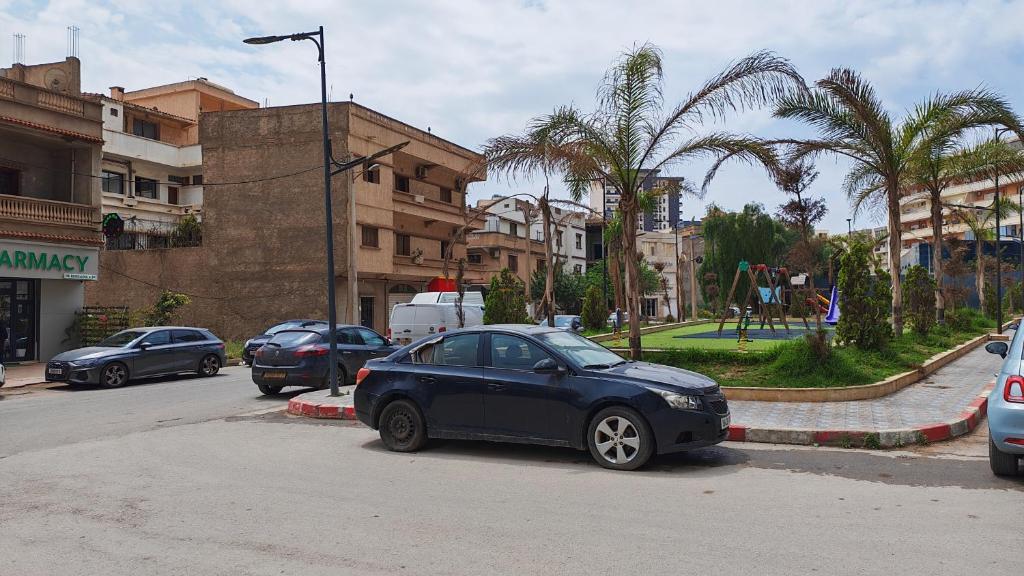 a blue car parked on the side of a street at Spacious accommodation with city views in Haï Khemisti
