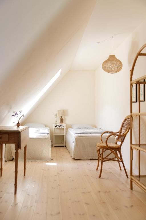 a attic bedroom with two beds and a desk at Atma Guesthouse - cozy and simple farmhouse bed & breakfast in Marstal