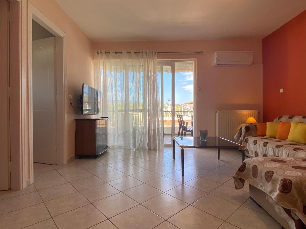 a living room with a couch and a television at Soft Horizon Apartment in Loutraki