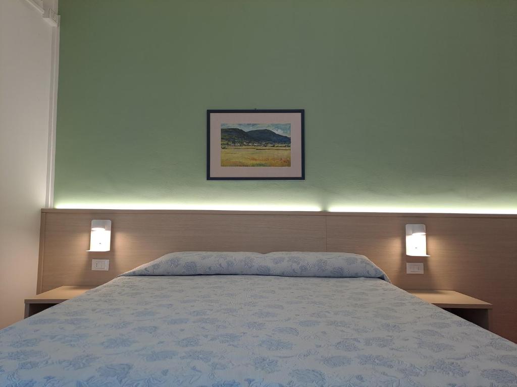 a bedroom with a bed with two nightstands and two lights at B&B Locanda Al Pontesel in Garda