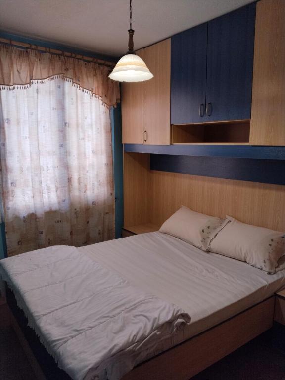 a bedroom with a large bed with a window at Moon e Sky in Tirana