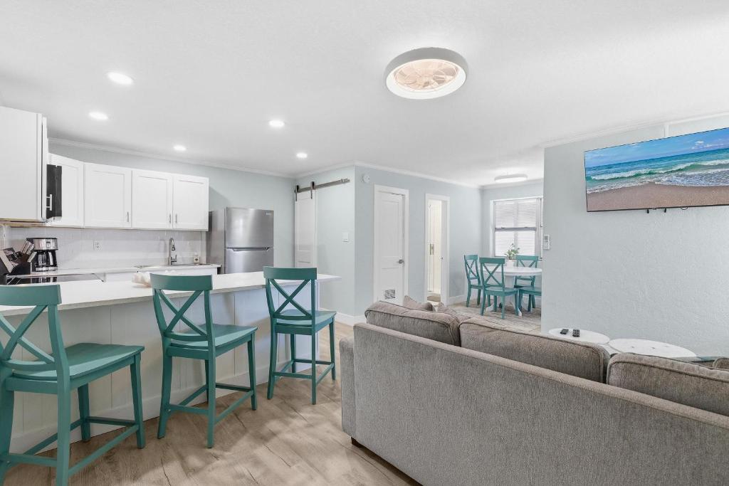 a living room and kitchen with a couch and chairs at Flagler Suites 1 in New Smyrna Beach