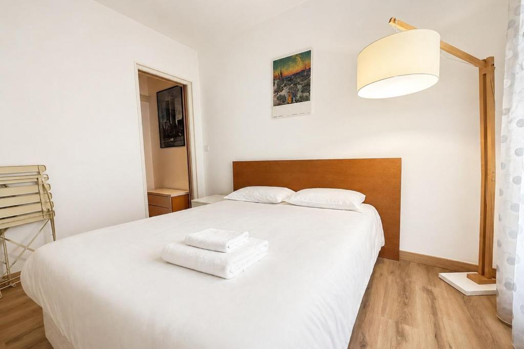 a white bed with two white towels on it at One-bedroom apt with balcony on Rue Hoche in Cannes