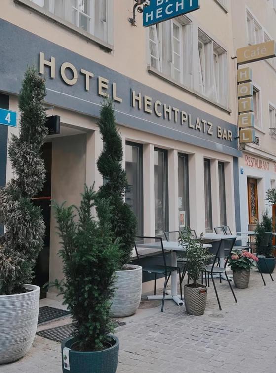 a hotel with a table and potted plants in front of it at Hotel Hechtplatz Self Check In in Zurich