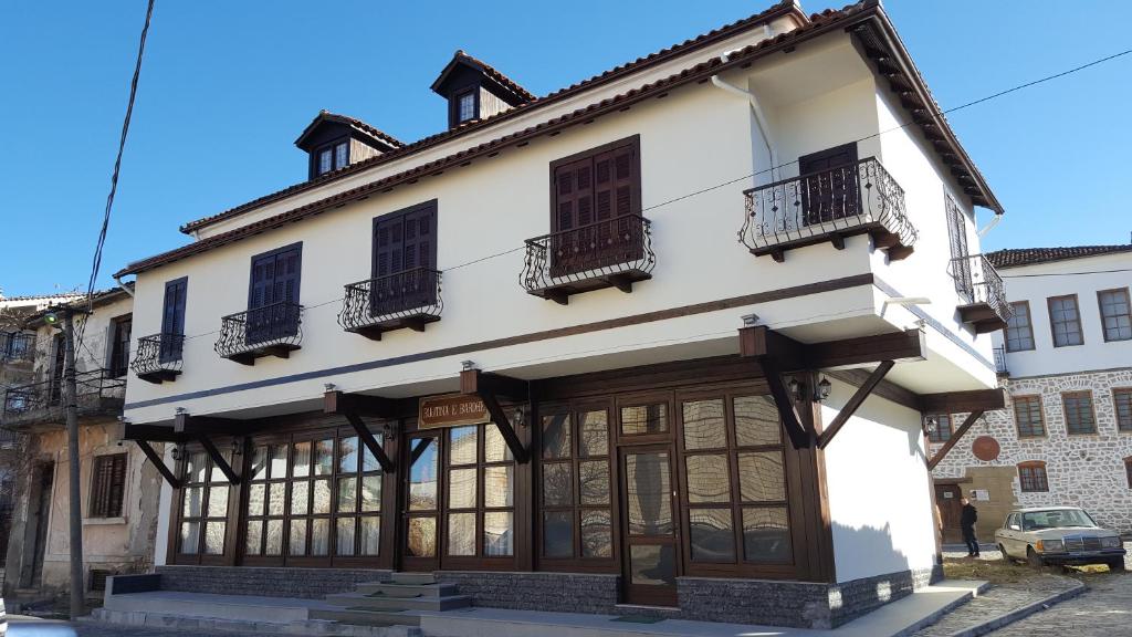- un bâtiment avec des fenêtres et des balcons dans une rue dans l'établissement Hotel Bujtina e Bardhe, à Korçë