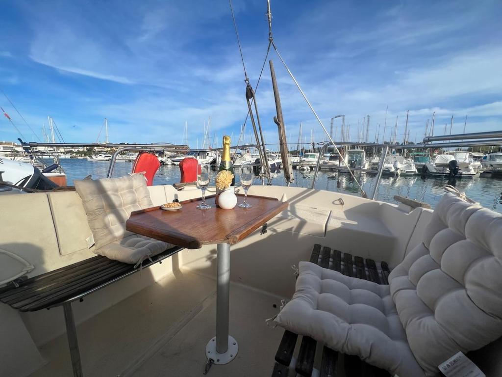 a table and chairs on a boat in a marina at Nuit insolite sur un bateau in Cap d'Agde