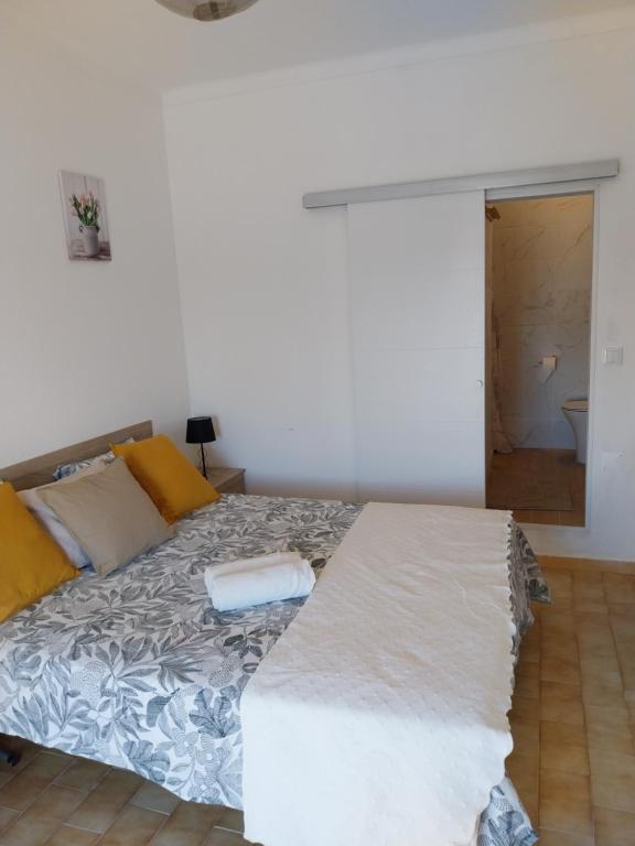 a bedroom with a bed and a door to a bathroom at Bienvenue chez Rosa in Vila Real de Santo António