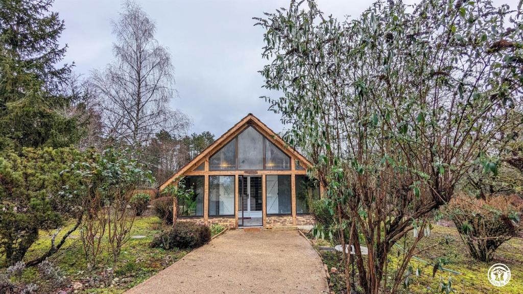 a house with a glass door in a garden at Le Chalet de la Combe Sainte-Anne in Selongey
