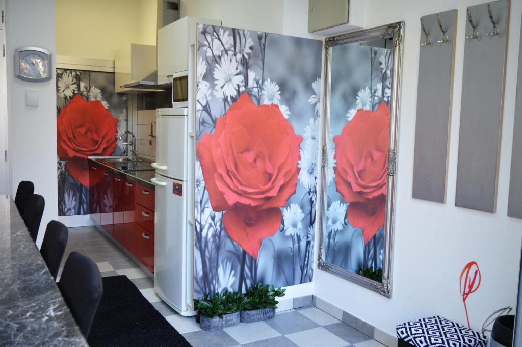 a kitchen with red flowers painted on the wall at Studio Two Roses in Split