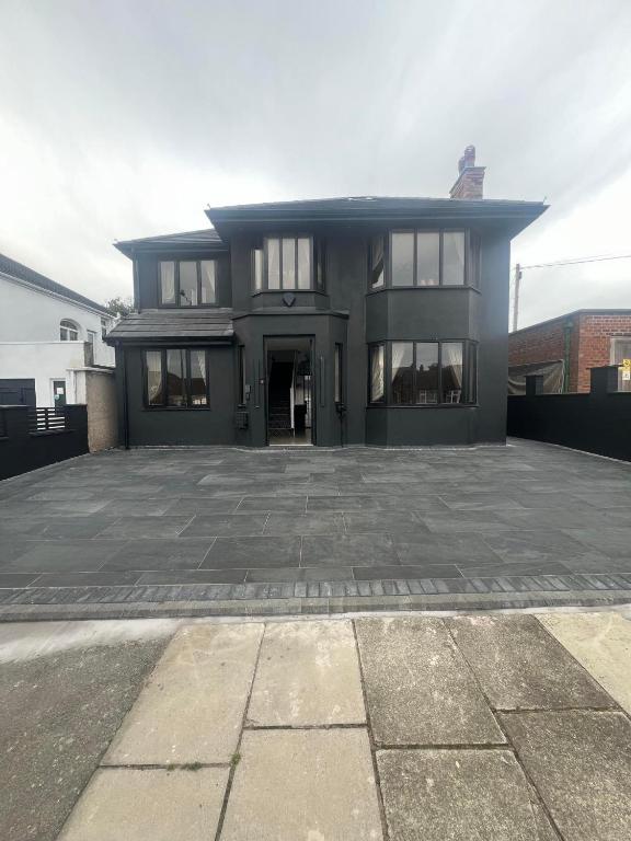 a large black house with a large driveway at 4 Bayswater in New Brighton