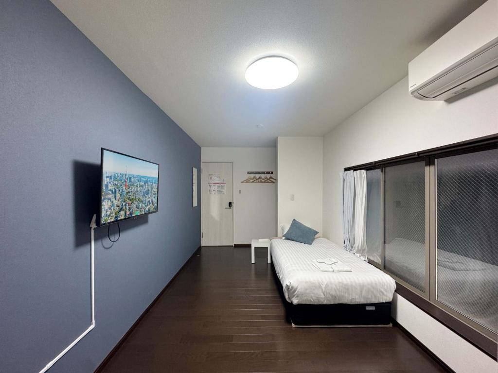 a room with a bed and a tv on a wall at D Hotel - Vacation STAY 89676v in Tokyo
