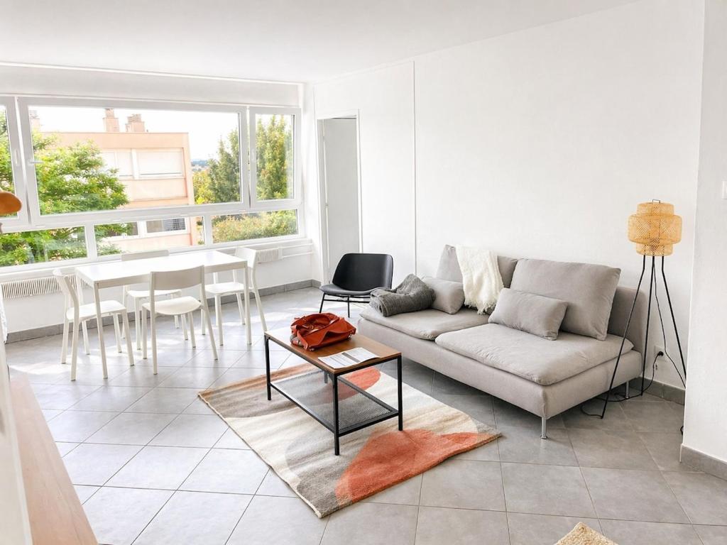 a living room with a couch and a table at Douce escale lumineuse à Nancy in Nancy