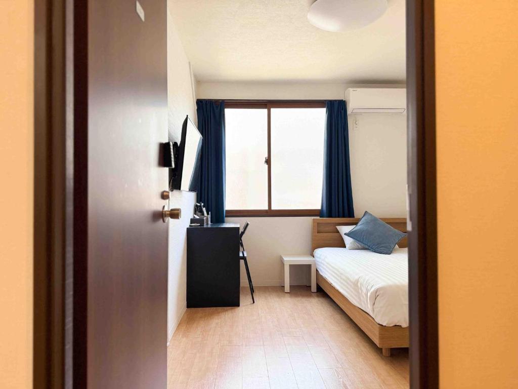 a small bedroom with a bed and a window at D Hotel - Vacation STAY 14103v in Tokyo