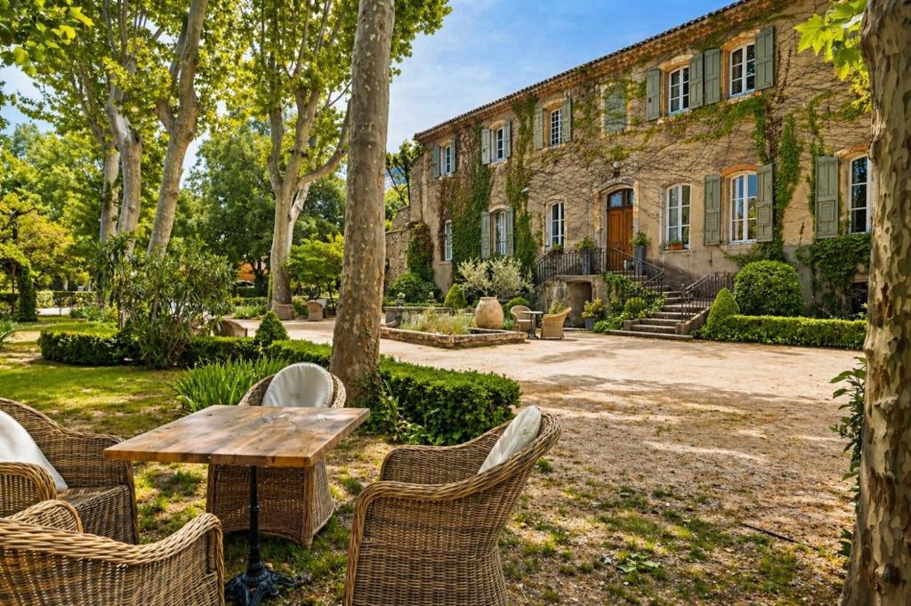 a table and chairs in front of a building at Château De Jouques in Gémenos